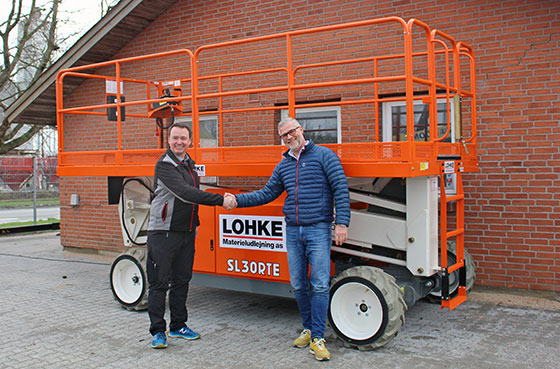 Lars Bruun Spange, Sales Manager at KH Lift ApS (left) hands over a Snorkel SL30RTE to Peter Kew, Owner at LOHKE Materieludlejning (right)